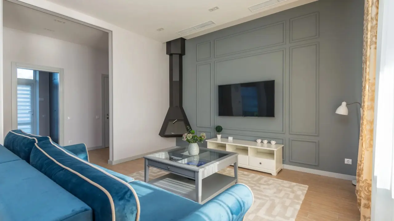 A modern living room with a bold blue wall and simple furniture